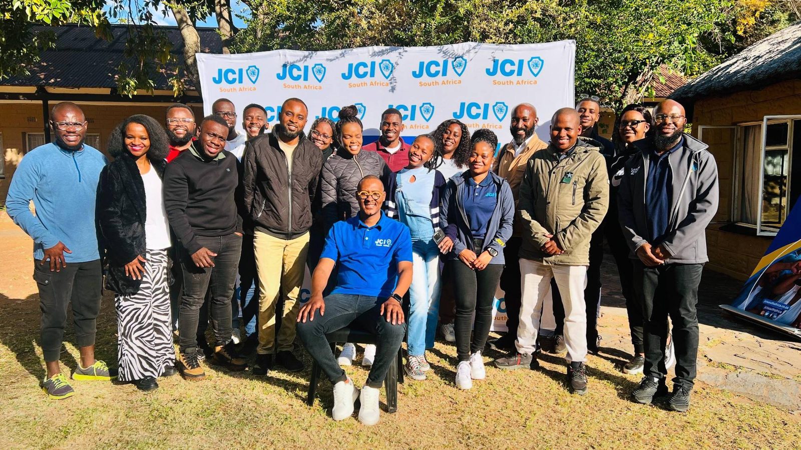 JCI South Africa members outdoors in front of the JCI South Africa banner