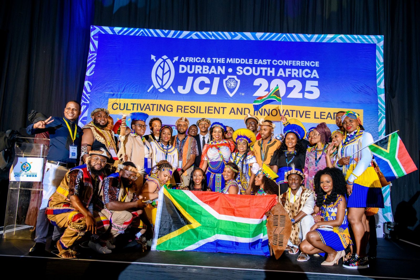 Team JCI South Africa in traditional attire with the South African flag at the JCI Africa and the Middle East Conference, Durban 2025